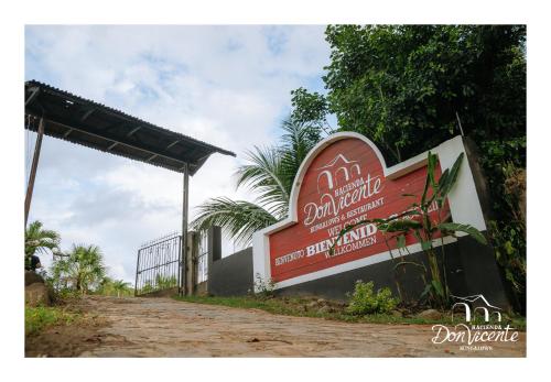 a sign for a hotel on the side of a dirt road at Hacienda Don Vicente Bungalows-Tarapoto in Tarapoto