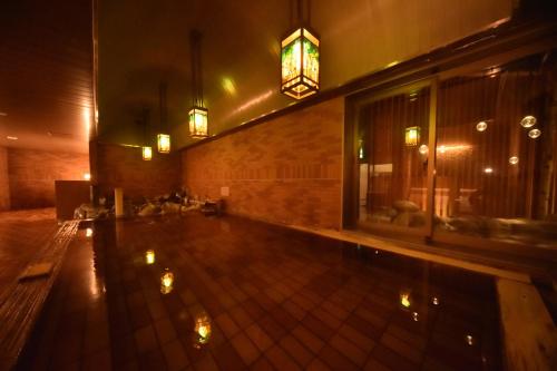 a pool in the middle of a building at night at Dormy Inn Premium Otaru in Otaru