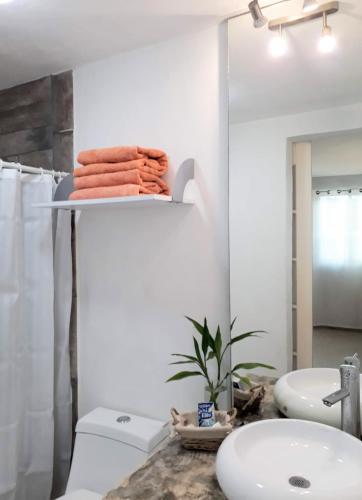 a bathroom with a toilet and a sink and a mirror at TR3S by Walter de la Renta in Cancún