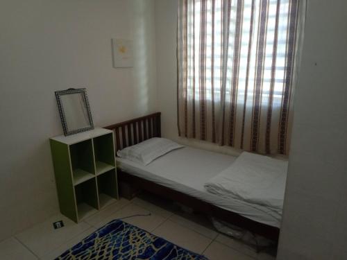 Hazz Homestay Alor Setar في ألور سيتار: غرفة نوم صغيرة بها سرير ونافذة