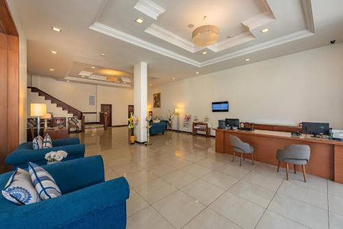 a lobby with two blue couches and a bar at The Pearl in Hassan