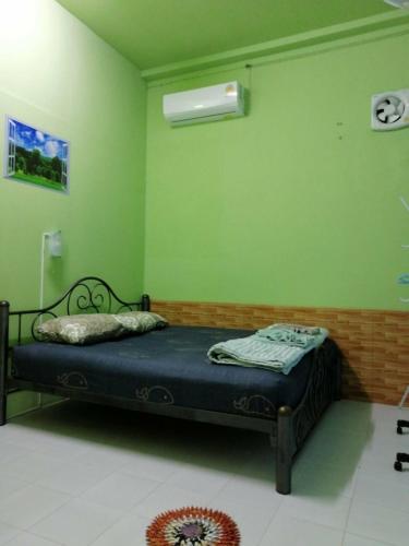 a bedroom with a bed in a green wall at Auntie House985 in Phra Nakhon Si Ayutthaya