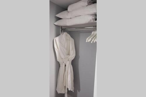 um armário com toalhas brancas num cabide em 1-Bedroom Mi Casita by Amazing Property Rentals em Gatineau