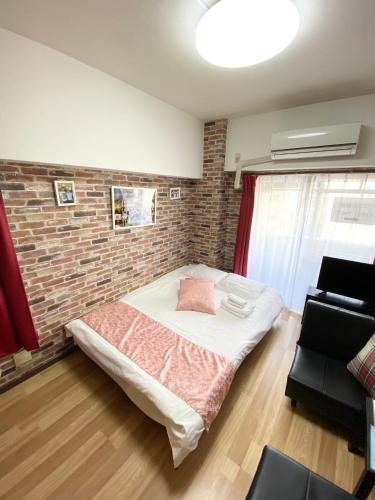 a room with a bed and a brick wall at La Foret Fujimi in Hiroshima