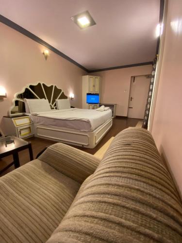 a living room with two beds and a couch at HOTEL VENUS in Ooty