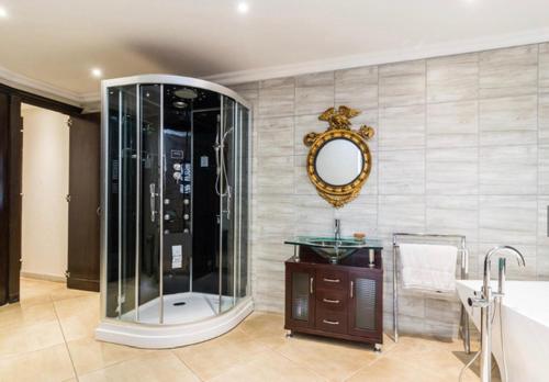 a bathroom with a shower and a sink and a mirror at inn on mars in Pretoria