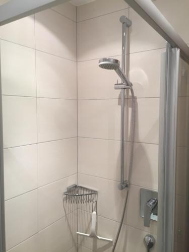 a shower in a bathroom with white tiles at Haus Petrasch "555" in Pfunds