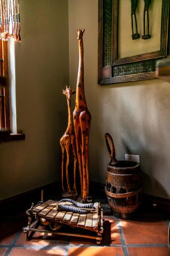 two wooden giraffes and a basket on a table at Terra Casa Guesthouse in Rustenburg