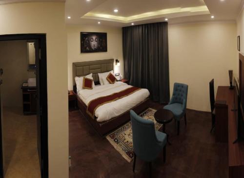 a hotel room with a bed and a desk and chairs at Hotel Paradise Ladakh in Leh