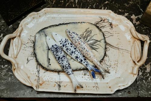 a plate with three fish on top of it at Terra Casa Guesthouse in Rustenburg