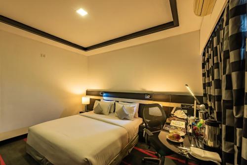 a hotel room with a bed and a desk at The Pearl in Hassan