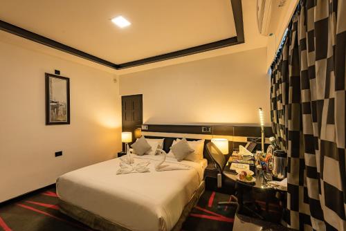a hotel room with a bed and a desk at The Pearl in Hassan
