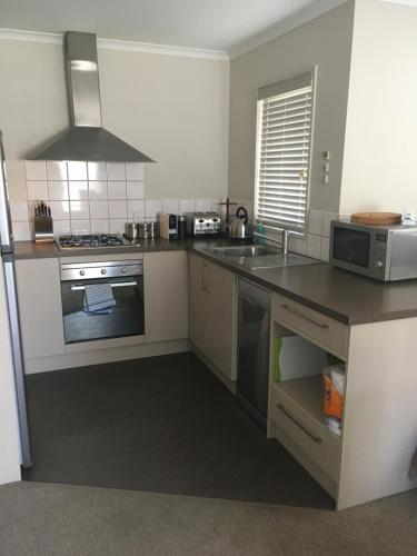 a kitchen with a sink and a stove top oven at Westport Central Apartment in Westport