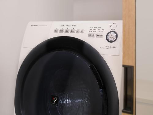 a white washing machine with a black door at nol kyoto sanjo in Kyoto