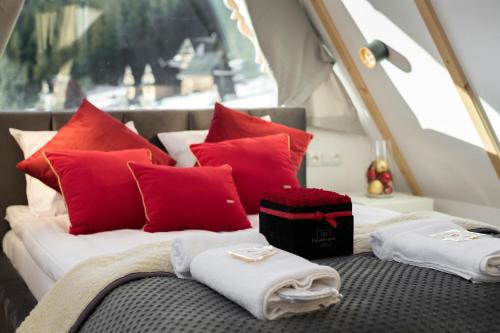 a bed with red and white pillows on a boat at Osada Gubałówka na Polanie Pająkówka & SPA in Kościelisko