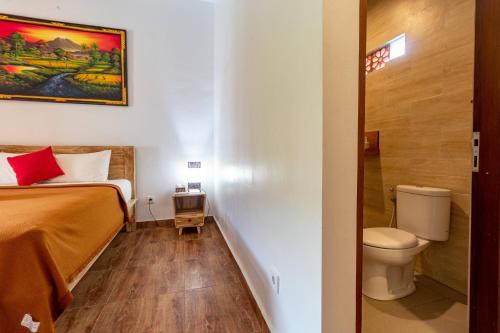 a small room with a bed and a toilet at Pondok Juli Canggu in Canggu