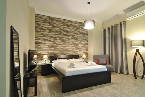 a bedroom with a large bed and a brick wall at Studio 20 (the best spot in town !) in Patra