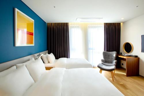 a hotel room with a bed and a chair at Hotel Arte in Suwon