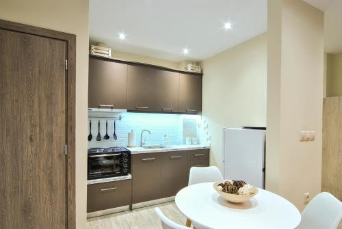 a kitchen with a white table and chairs and a kitchen with a sink at Studio 20 (the best spot in town !) in Patra