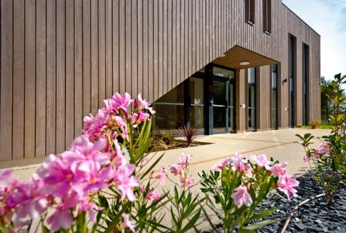 a building with pink flowers in front of it at Kyriad Résidence Cabriès - Plan de Campagne in Cabriès