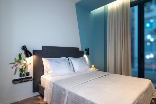 a hotel room with a white bed and white comforter at Athens One Smart Hotel in Athens
