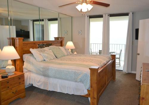 - une chambre avec un grand lit et un grand miroir dans l'établissement Sunswept 807, à Orange Beach