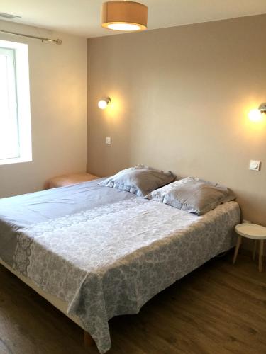 une chambre avec un grand lit avec deux oreillers dans l'établissement gîtes la ferme de marguerite, à Tulette