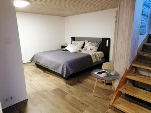 a bedroom with a bed and a table in it at Ferienwohnung Blockhaus Juka in Vinningen