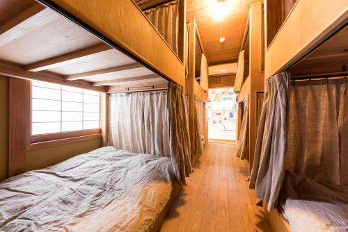 a bedroom with two bunk beds and a hallway at Guest House Maru in Kashima