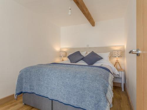 a bedroom with a bed with a blue blanket at Potters by the Sea in Penzance
