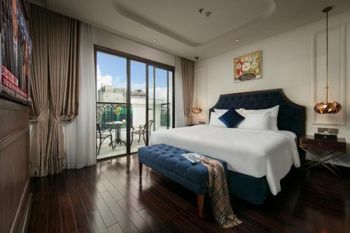 a bedroom with a large bed and a large window at Anatole Hotel Hanoi in Hanoi