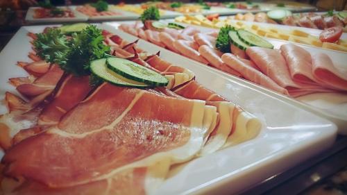 un buffet de diferentes tipos de comida en platos en BSW-Erlebnishotel Festenburg, en Clausthal-Zellerfeld