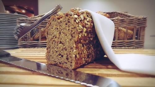 Una hogaza de pan sobre una mesa con un cuchillo en BSW-Erlebnishotel Festenburg, en Clausthal-Zellerfeld