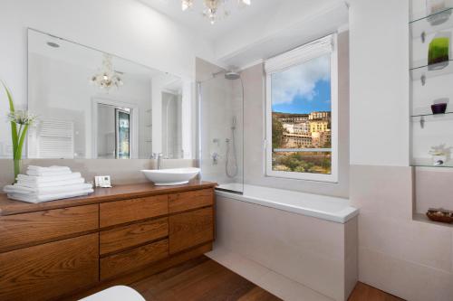baño con lavabo, bañera y ventana en Luxury Home Sea View & Jacuzzi in Sorrento centre, en Sorrento