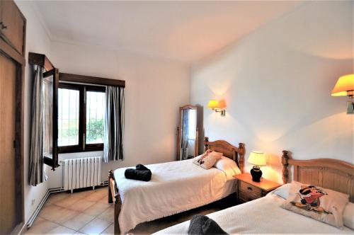 a bedroom with two beds and a window at XOROI- Villa primera linea mar con vistas a Bahía Alcudia in Artá