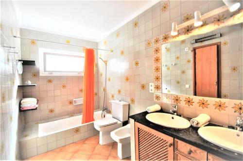 a bathroom with a sink and a toilet and a mirror at XOROI- Villa primera linea mar con vistas a Bahía Alcudia in Artá