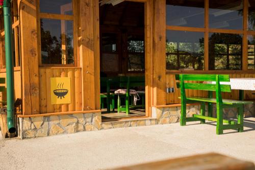 a green bench in front of a store window at Apartments&Camping ZIP in Kremna