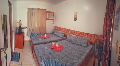 a room with a couch with two toys on it at WHITE BEACH GUEST HOUSE in Puerto Galera