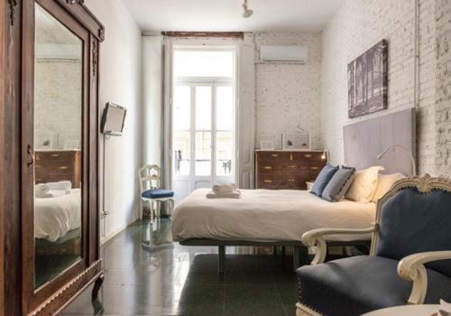 a bedroom with two beds and a mirror and a chair at ABCyou Bed&Breakfast in Valencia