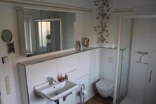 a white bathroom with a sink and a toilet at Ferienwohnung am Park in Erfurt
