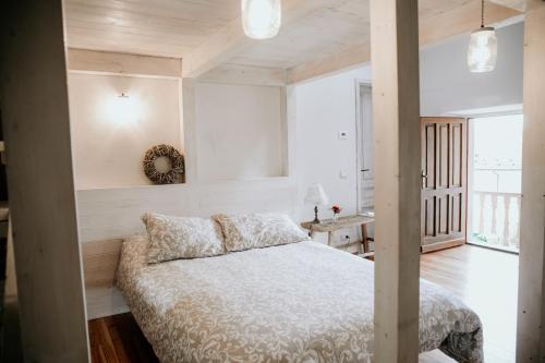 a bedroom with a bed with white walls at Guest House Al Devesio in Rifreddo