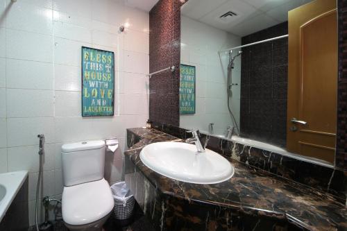 a bathroom with a sink and a toilet and a mirror at Studio Apartment in Zumurud Tower , Dubai Marina in Dubai