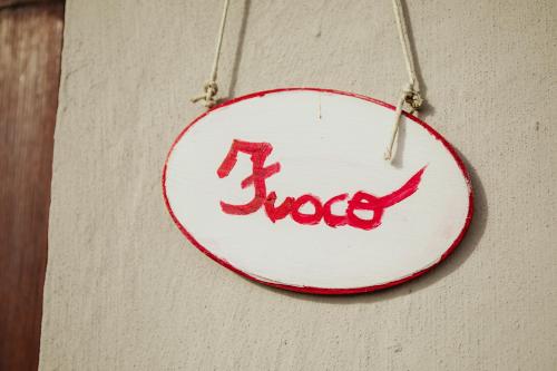 a white plate with the word hug hanging on a wall at Guest House Al Devesio in Rifreddo