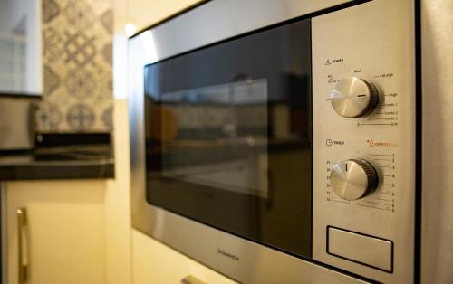 a microwave oven with two knobs on it at Appartements Rabat Balima Harcourt in Rabat