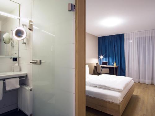 a hotel room with a bed and a bathroom at Hotel Berlin in Sindelfingen