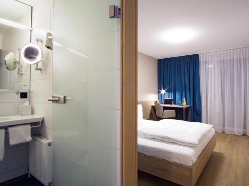 Cette chambre comprend un lit et une salle de bains. dans l'établissement Hotel Berlin, à Sindelfingen