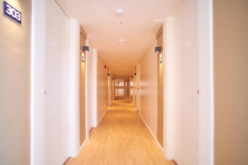 an empty hallway in a building with white walls and wooden floors at Bridge Hotel Express in Cagayan de Oro