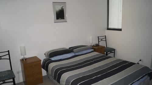 1 dormitorio con 1 cama, 2 sillas y ventana en Manhattan on Glebe Park en Canberra