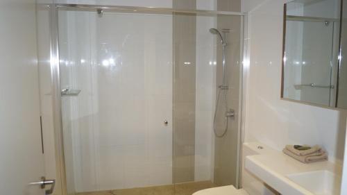a bathroom with a shower and a toilet and a sink at Manhattan on Glebe Park in Canberra