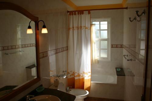 uma casa de banho com um lavatório, um WC e uma janela. em Complejo Solymar em Puerto Naos